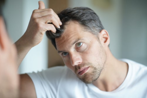 mens hair loss solutions in garden city, man checking out his hair